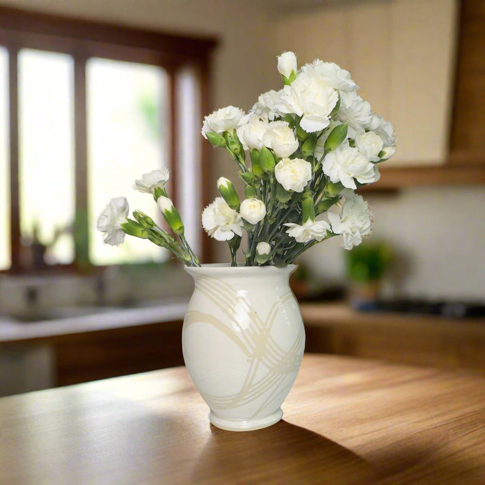 White vases with clear lines with white flowers inside