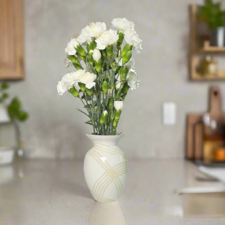 
                      
                        Medium white gloss vase with clear lines. with white flowers as decoration inside
                      
                    